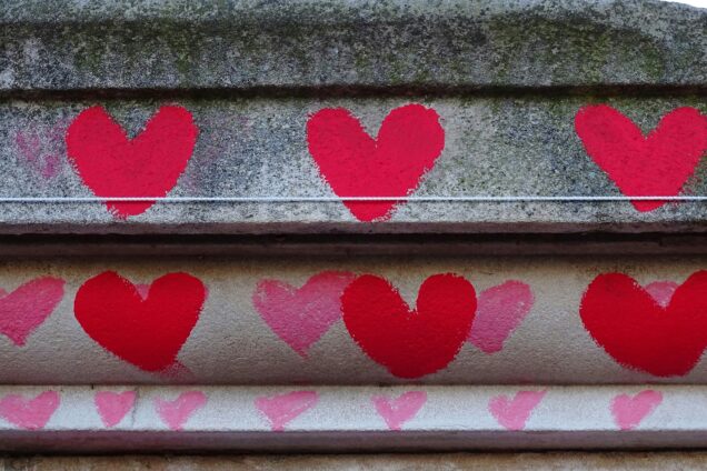 Čtyři červená srdce namalovaná na kamenných schodech jako symbol postupné cesty k budování důvěry v marketingu.