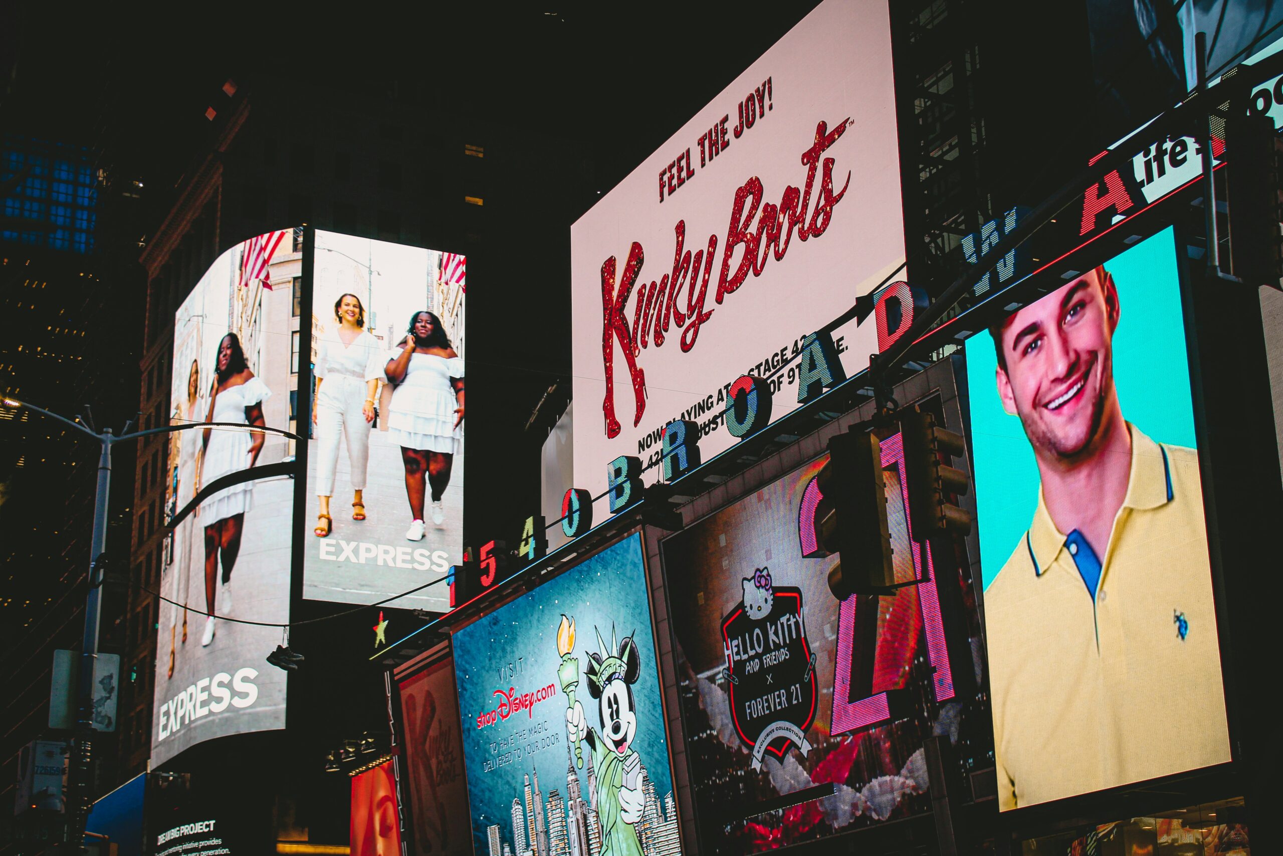 Město zaplavené svítícími billboardy a reklamou jako symbol marketingové přesycenosti.